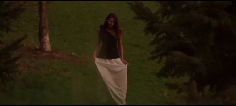 A model in a pale skirt moving through the trees